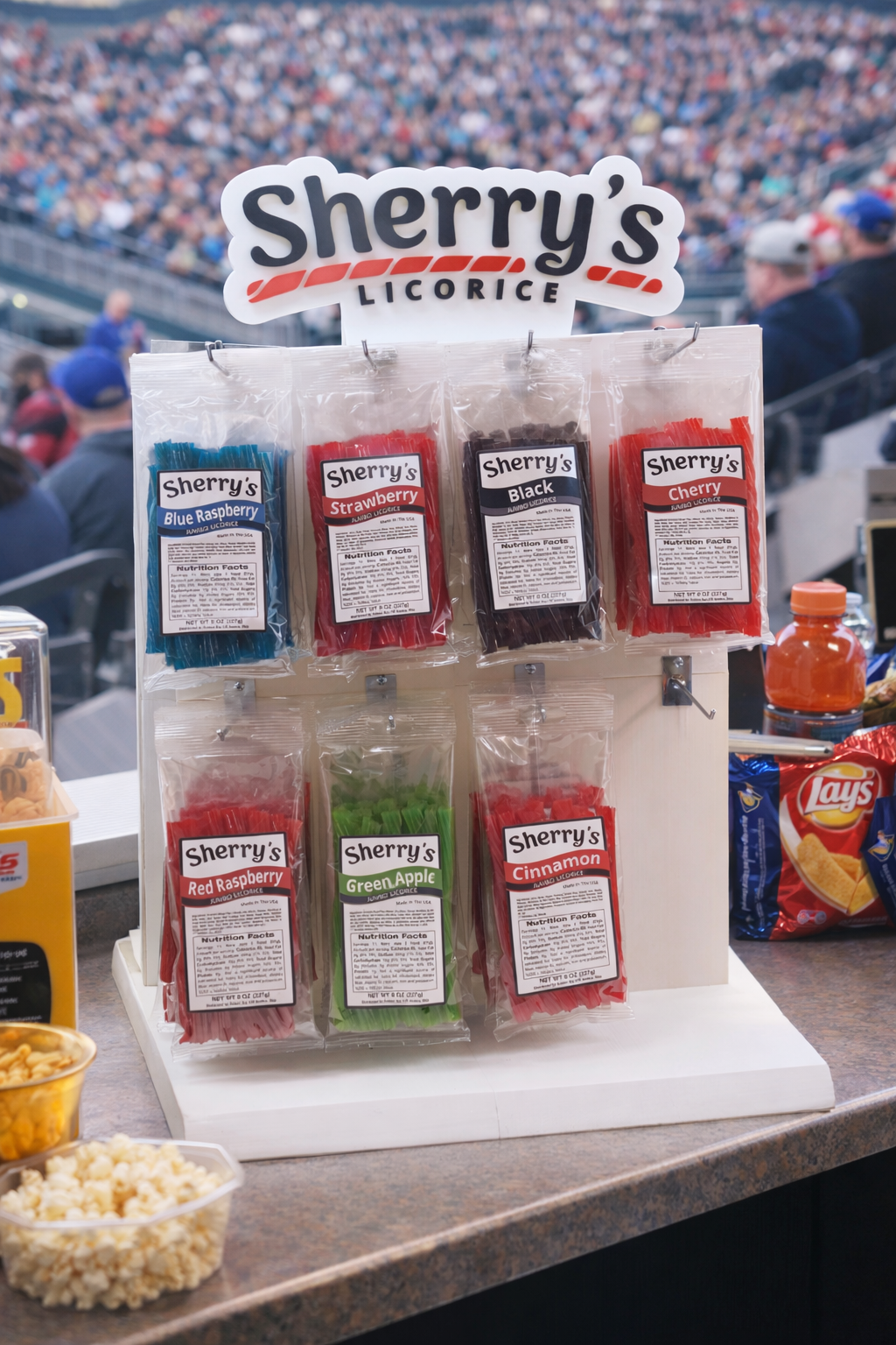 Display of Sherry's Licorice at a sports event with a crowd in the background.